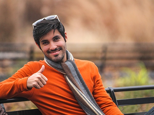 Man sitting on bench and giving a thumbs up