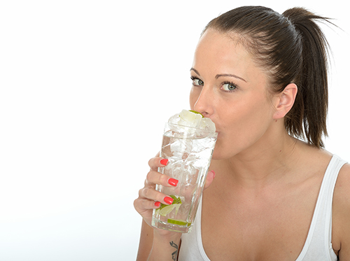 Woman sipping on drink with ice